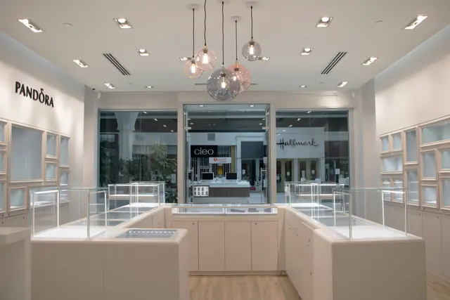 Bright jewellery store interior with white display cases and glass pendant lights