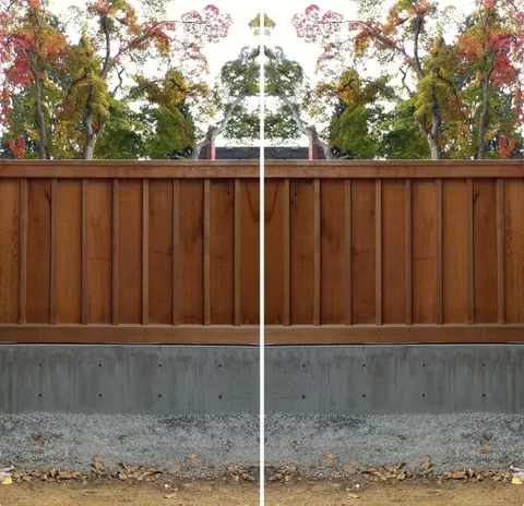 A long cedar wall of horizontal boards on a concrete base