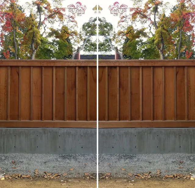 A long cedar wall of horizontal boards on a concrete base