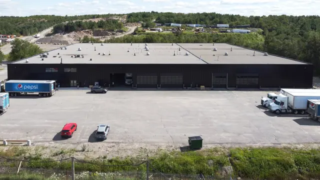 Aerial view of the large single-storey industrial building with trucks at the loading doors