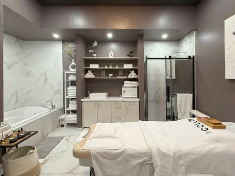 Private treatment room with a massage table, soaker tub and marble-look walls